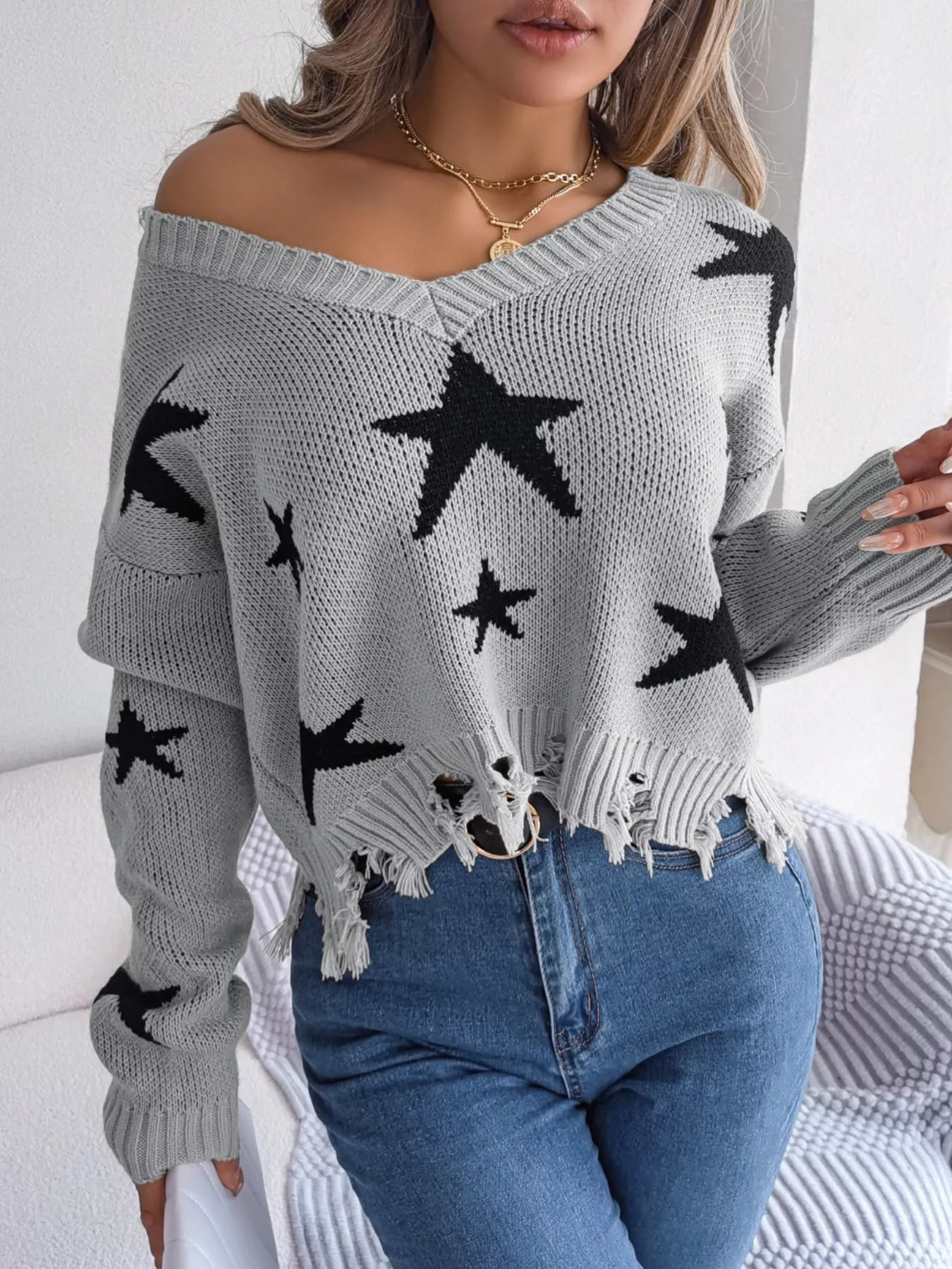 Woman in star pattern distressed sweater by fall leaves