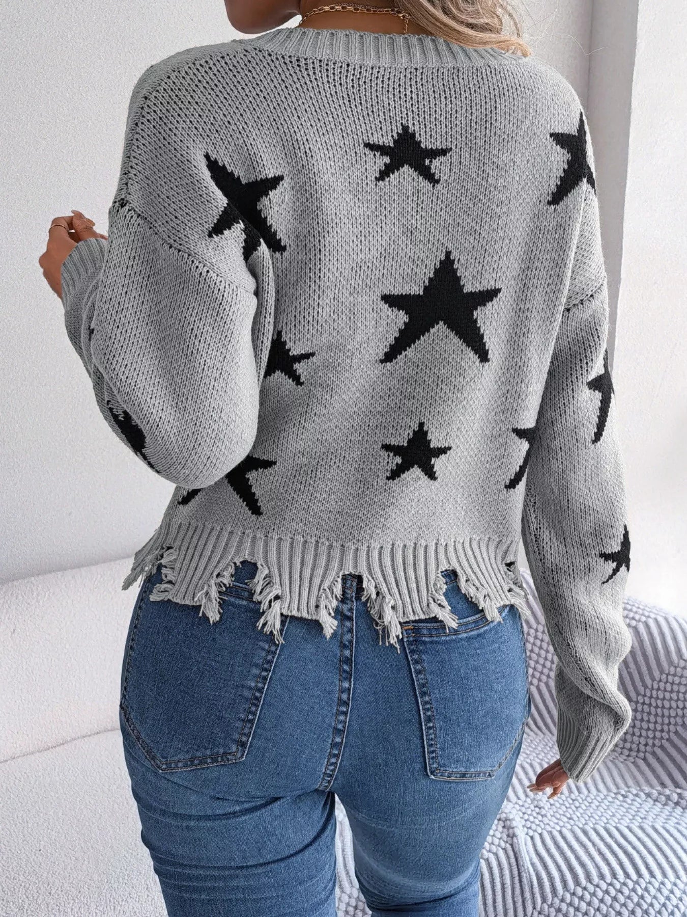 Woman in star pattern distressed sweater by fall leaves