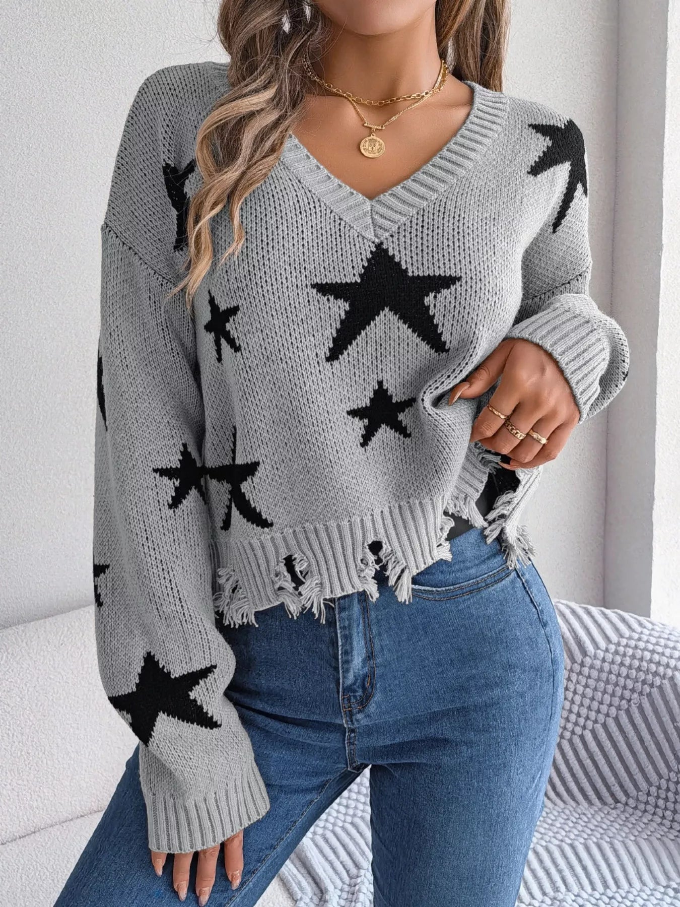 Woman in star pattern distressed sweater by fall leaves