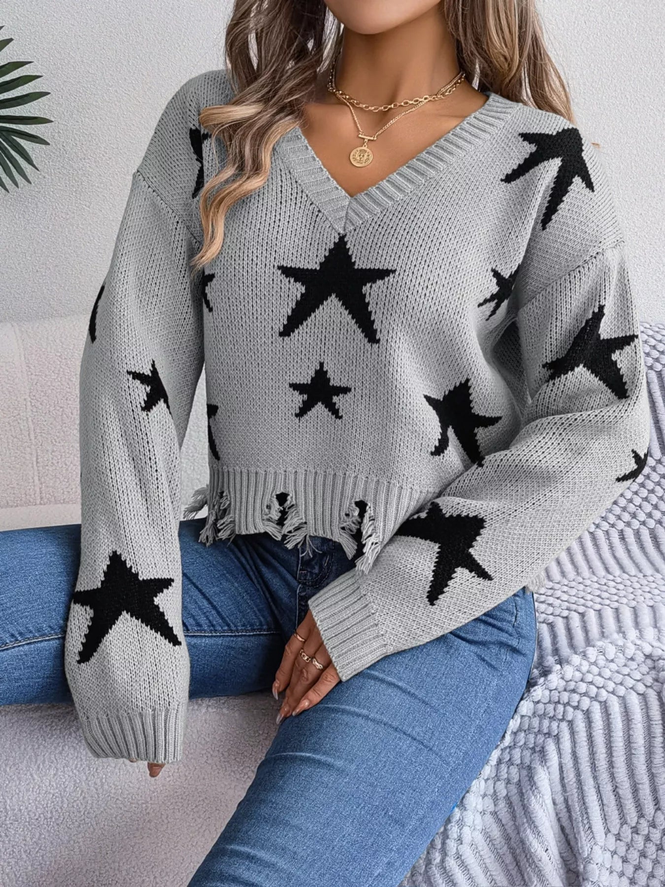 Woman in star pattern distressed sweater by fall leaves