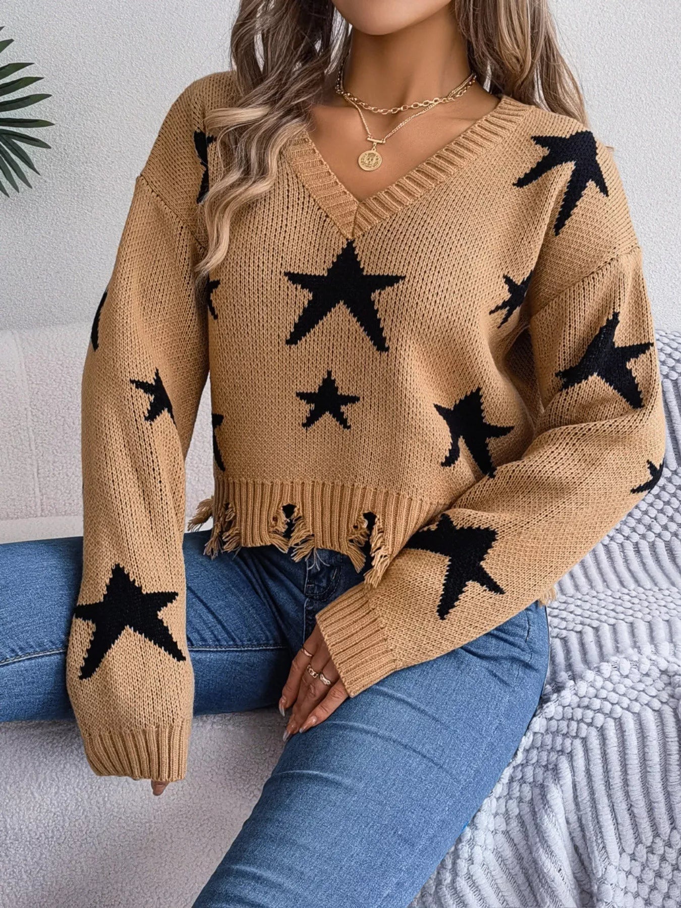 Woman in star pattern distressed sweater by fall leaves