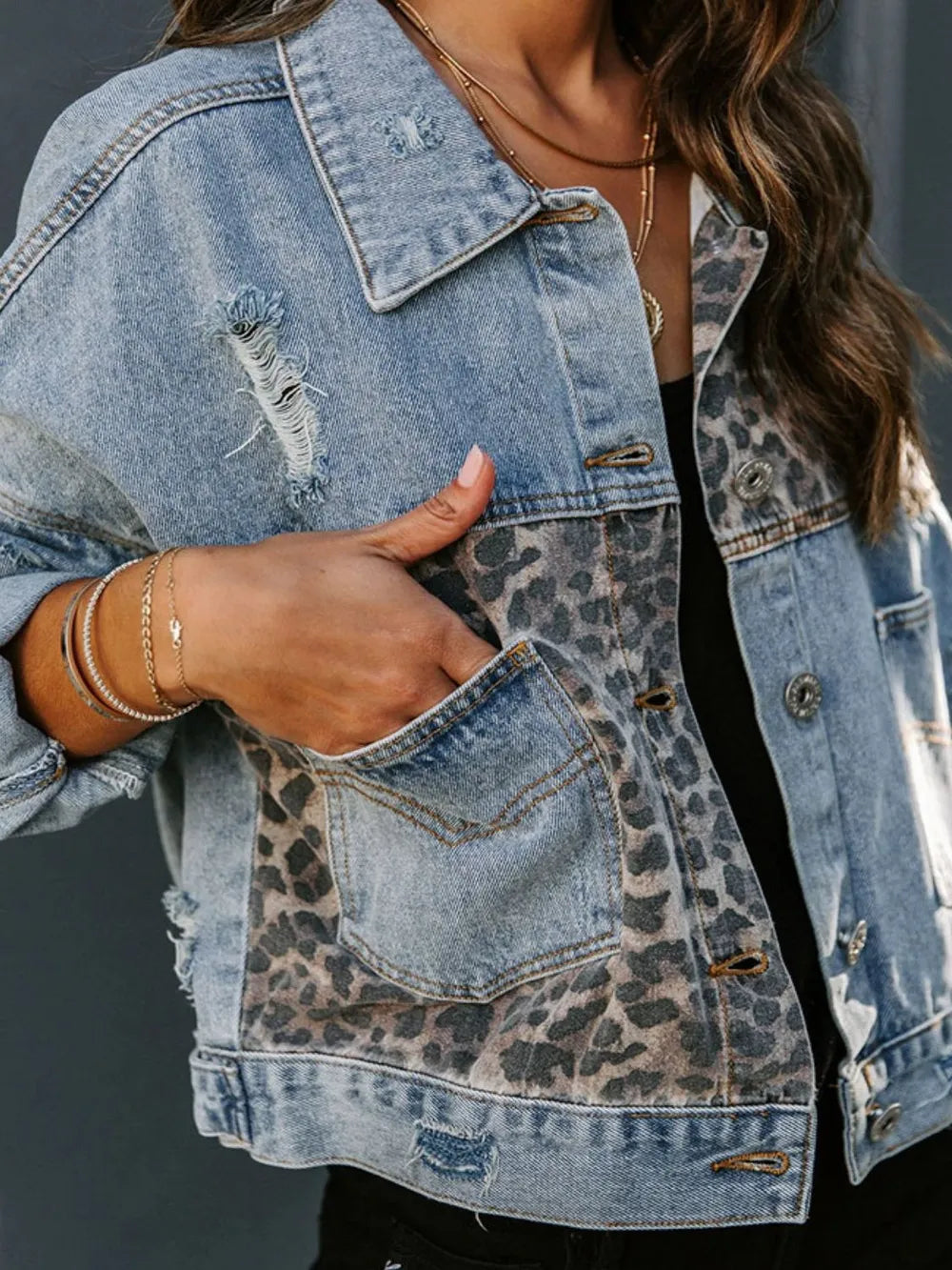 Front view of distressed leopard denim jacket on woman