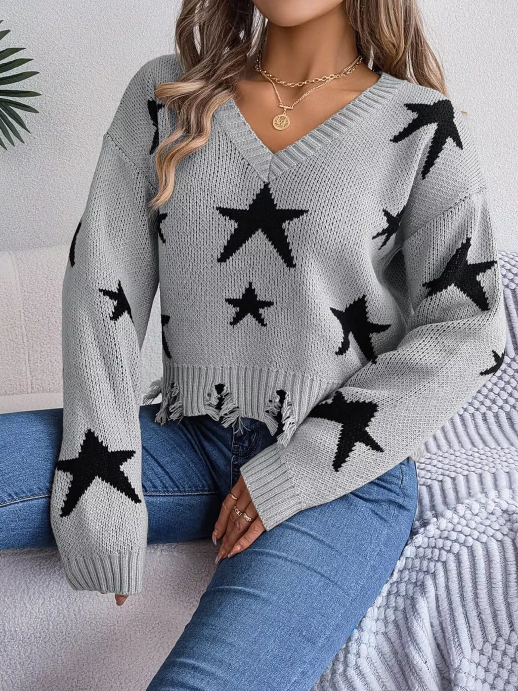 Woman in star pattern distressed sweater by fall leaves